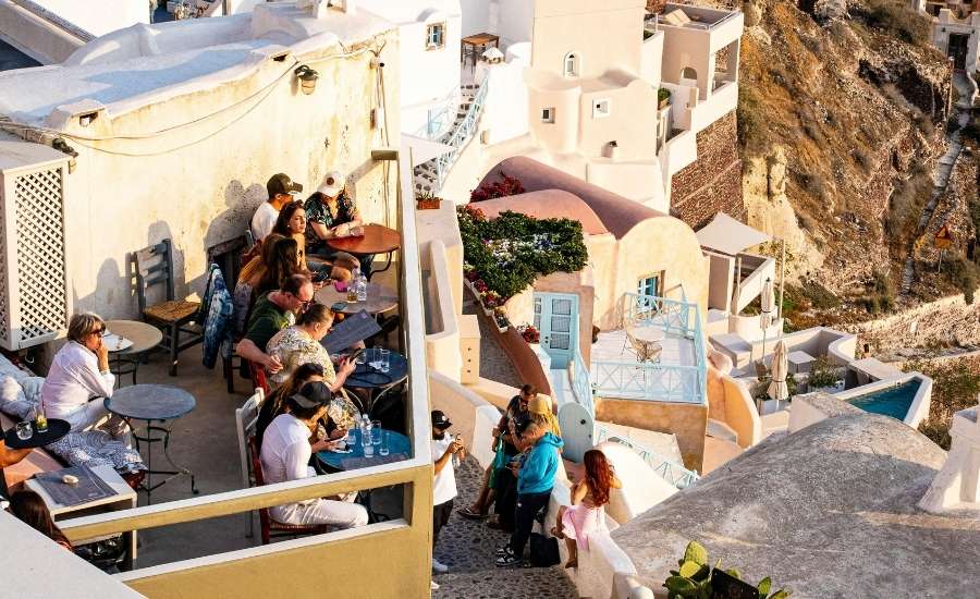 People sat in a cliffside bar in Fira