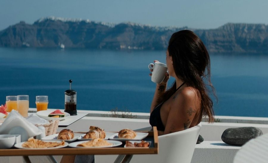 Woman sitting at table with view of the ocean