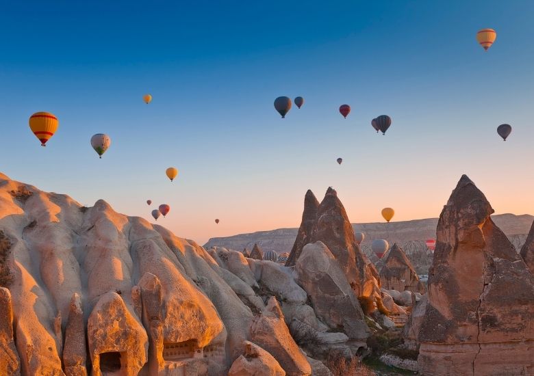 Hot air balloons floating over cliffs in Turkey